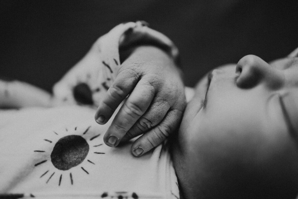 black and white image of a newborn's hand plano newborn photographer